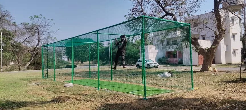 Outdoor cricket practice cage enclosed with green netting